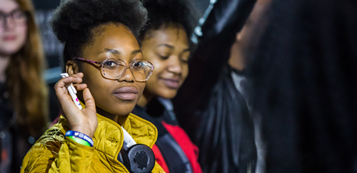 Photo of UK Youth (young women with glasses, in a yellow jacket)