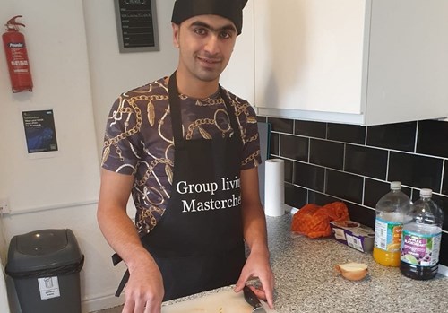 Group Living participant prepares food.