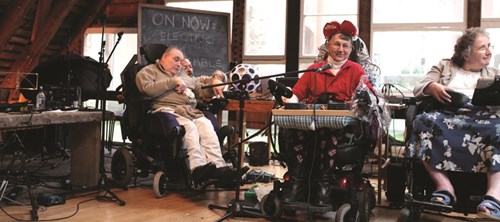 A musical ensemble performs from wheelchairs.